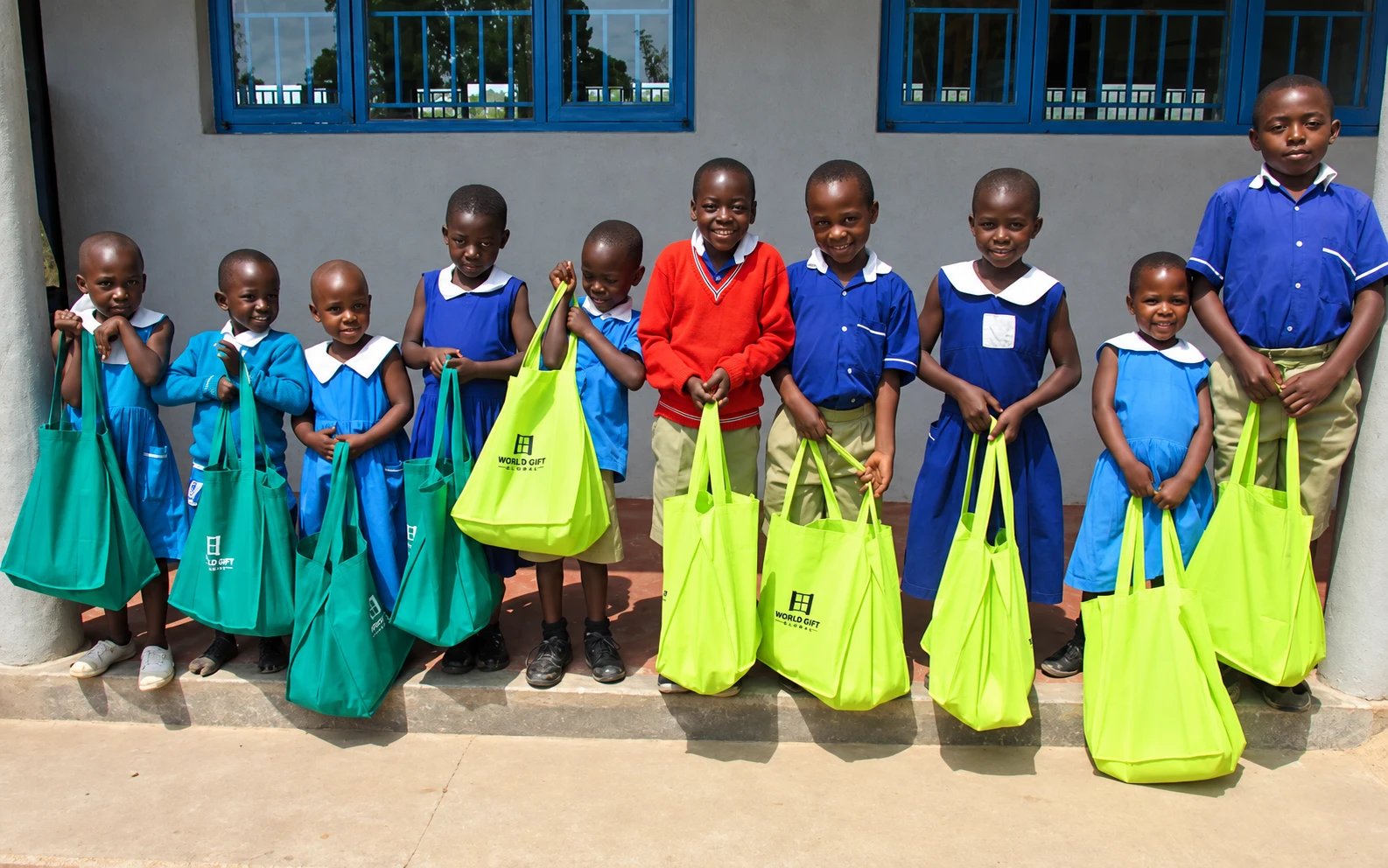 Schoolchildren in uniform holding colorful tote bags Schoolchildren in uniform holding colorful tote bags